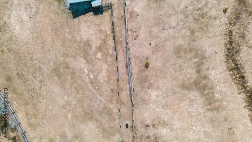 An abandoned farmhouse in the mountains of Norway. A hiker travels along a narrow path surrounded by a wooden fence. Drone view from above. Billingen, Norway photo