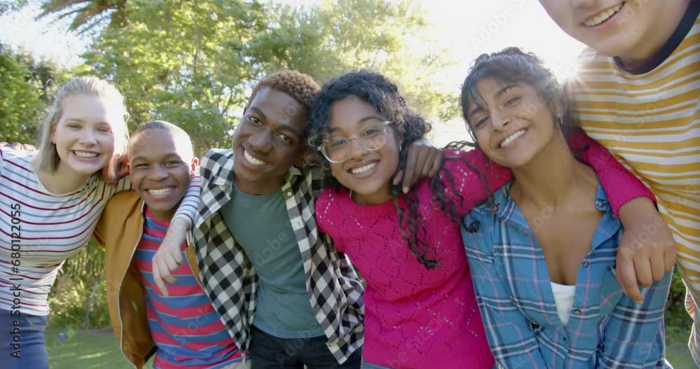 Portrait of happy diverse group of teenage friends embracing in sunny park, slow motion Portrait of happy diverse group of teenage friends embracing in sunny park, slow motion