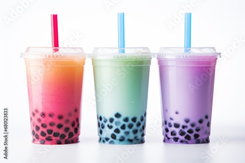 Three bubble tea drinks in plastic cups with straws