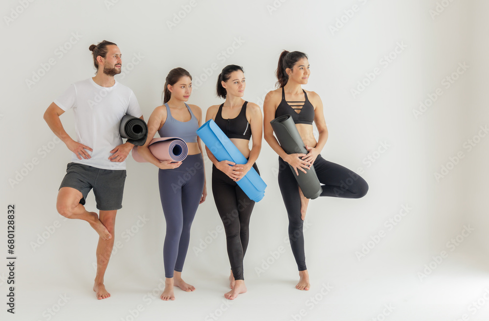 Obraz premium Group of Yoga Practitioners Poised with Mats Before Class