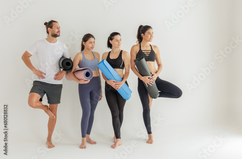 Group of Yoga Practitioners Poised with Mats Before Class
