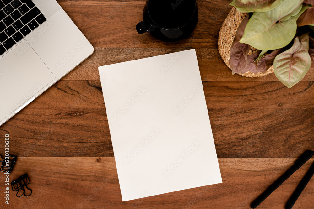 Φωτογραφία Empty blank white magazine cover mock up, laptop, stationery and cup of tea, houseplant flat lay on wood desk office