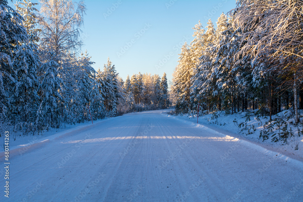 Snowy winter road with trees. Winter conditions in the North. Copy Space