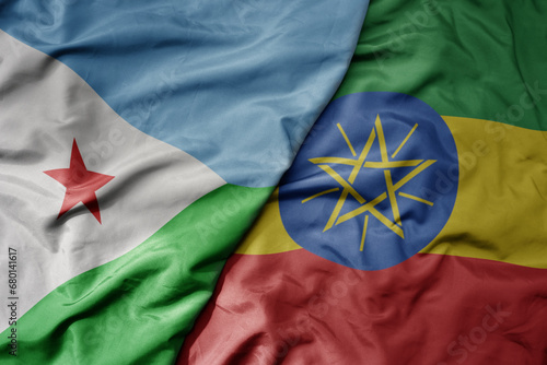 big waving national colorful flag of ethiopia and national flag of djibouti .