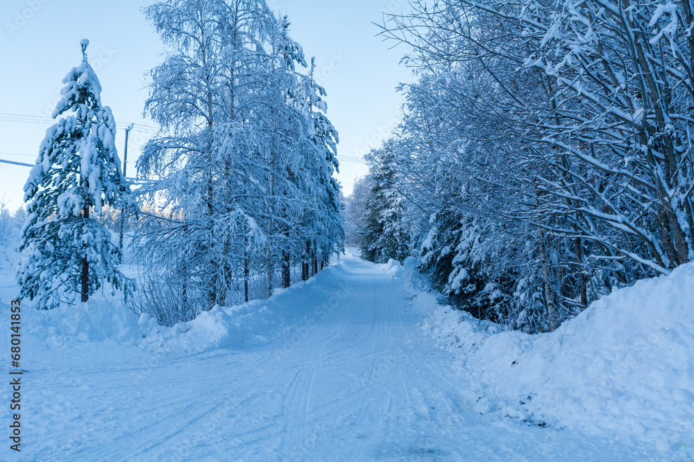 Snowy winter road with trees. Winter conditions in the North. Copy Space