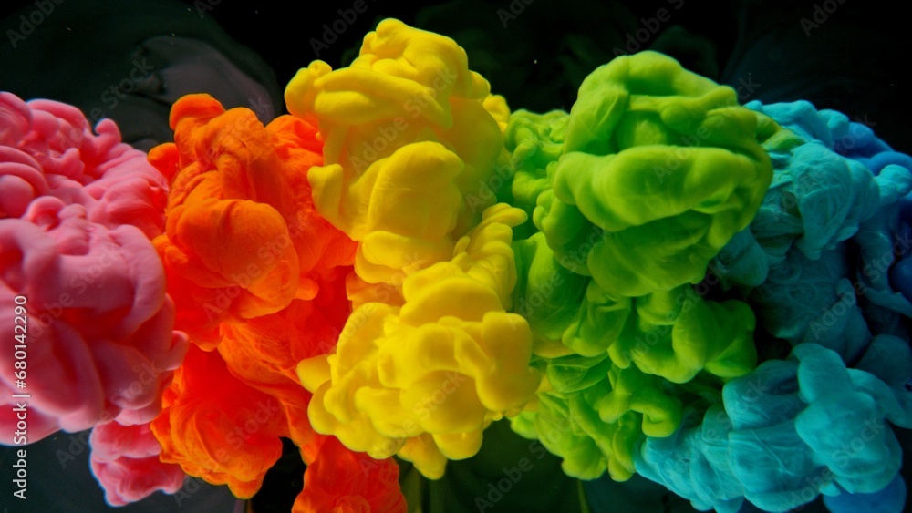 Obraz premium Colourful Rainbow Paint Drops Mixing in Water.
