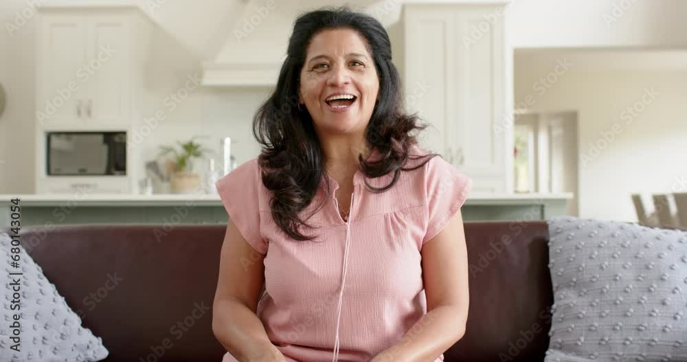 Happy biracial senior woman having video call and smiling in sunny living room, slow motion Happy biracial senior woman having video call and smiling in sunny living room, slow motion