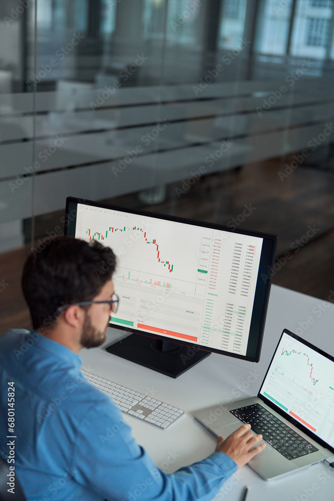 Busy business man trader broker analyst investor using laptop computer analyzing stock trade crypto market digital data investing finances in stockmarket working in dark office. Top view vertical. Busy business man trader broker analyst investor using laptop computer analyzing stock trade crypto market digital data investing finances in stockmarket working in dark office. Top view vertical.