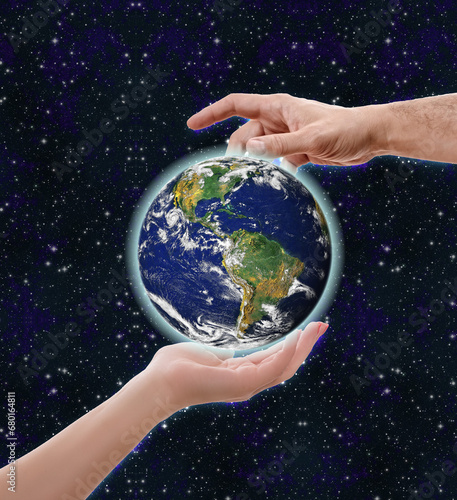 Jour de la Terre, 22 avril, actions pour diminuer impact sur environnement. Concept avec les mains de l'homme et de la femme entourant la planète sur fond étoilé photo