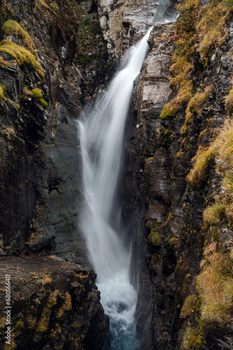 Silverfallet waterfall flowing between dark rocks  Kiruna region  Swedish Lapland
