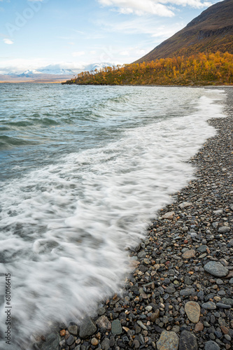 Waves crashing to the shore of the Torneträsk lake on a beautiful autumn day in Kiruna Municipality, Lapland, Norrbotten County in Sweden, in the Scandinavian Mountains.