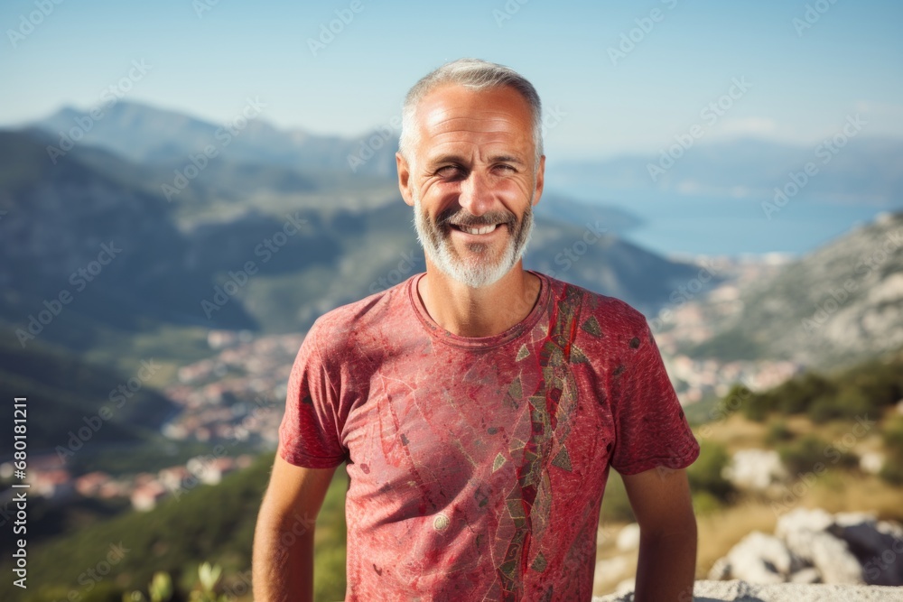 Portrait of a happy man in his 50s donning a trendy cropped top against a panoramic mountain vista. AI Generation
