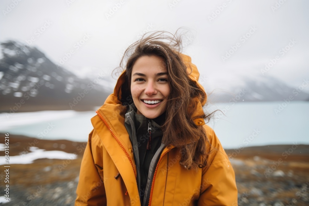 Portrait of a joyful woman in her 20s wearing a lightweight packable anorak against a backdrop of an arctic landscape. AI Generation