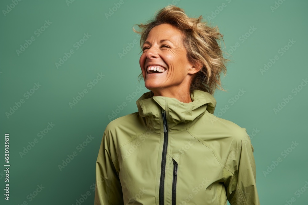 Portrait of a joyful woman in her 40s wearing a windproof softshell against a pastel green background. AI Generation Portrait of a joyful woman in her 40s wearing a windproof softshell against a pastel green background. AI Generation