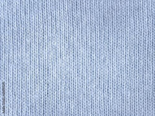 Background. Smooth knitted surface. The texture of knitted blue fabric. Close-up. Woolen threads of blue color. Knitted product. Texture. View from above. Copy space
