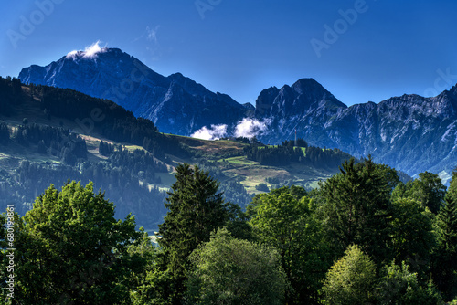 Beautiful panorama in the Austrian Alps in Salzburger Land near Saalfelden am Steinernen Meer, facing the Leoganger Steinberge with Birnhorn. Mountain peaks, alpine pastures, forests, and a blue sky.
