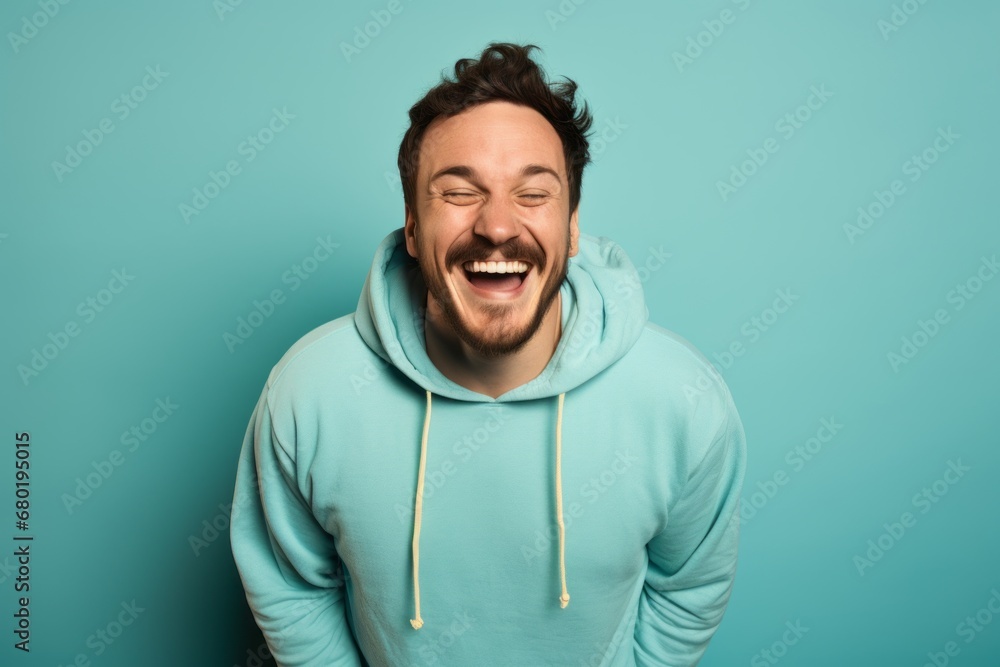 Portrait of a joyful man in his 30s sporting a comfortable hoodie against a soft teal background. AI Generation Portrait of a joyful man in his 30s sporting a comfortable hoodie against a soft teal background. AI Generation