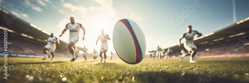 a rugby team runs after a rugby ball in the center of the panoramic image photo