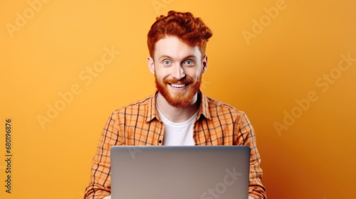 Smiling cheerful smart young ginger man wearing casual teenage clothes using laptop computer pose looking at camera isolated color background photo