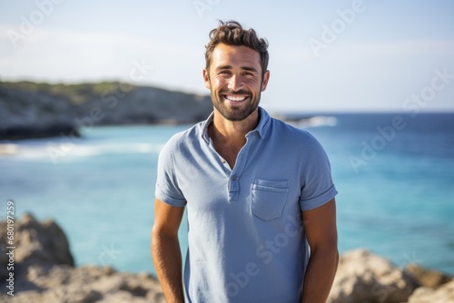 Portrait of a cheerful man in his 30s donning a classy polo shirt against a serene seaside background. AI Generation