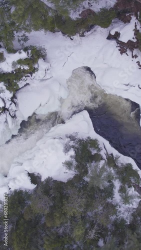 Aerial view of white winter landscape with a frozen river in the mountains with  flowing water in Laurentides Canada (ID: 680201827)