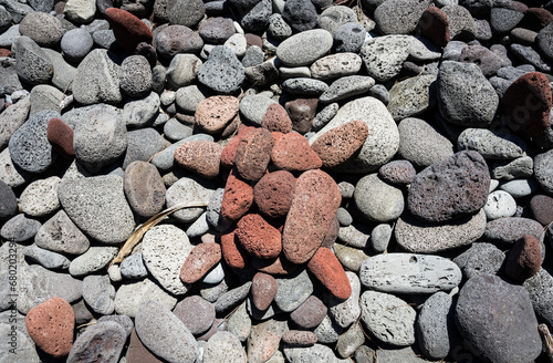 Hawaii red turtle made of red volcanic rock close up on beach pattern mosaic texture