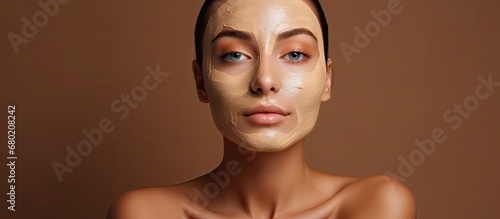 The young woman with flawless skin and a radiant face is taking care of her beauty using natural facial creams in a clean spa environment, surrounded by people.
