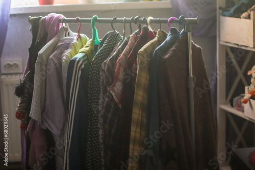 Clothes on hangers in a home. Second hand for swap. Concept of sustainable lifestyle and smart consumption photo