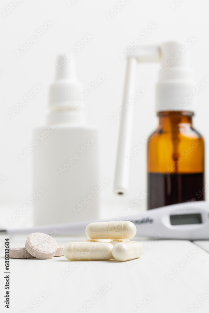 Cold remedies, medicines, thermometer, capsules and pills in a blister pack on wooden table. Healthcare concept, home treatment of flu and coronavirus Cold remedies, medicines, thermometer, capsules and pills in a blister pack on wooden table. Healthcare concept, home treatment of flu and coronavirus
