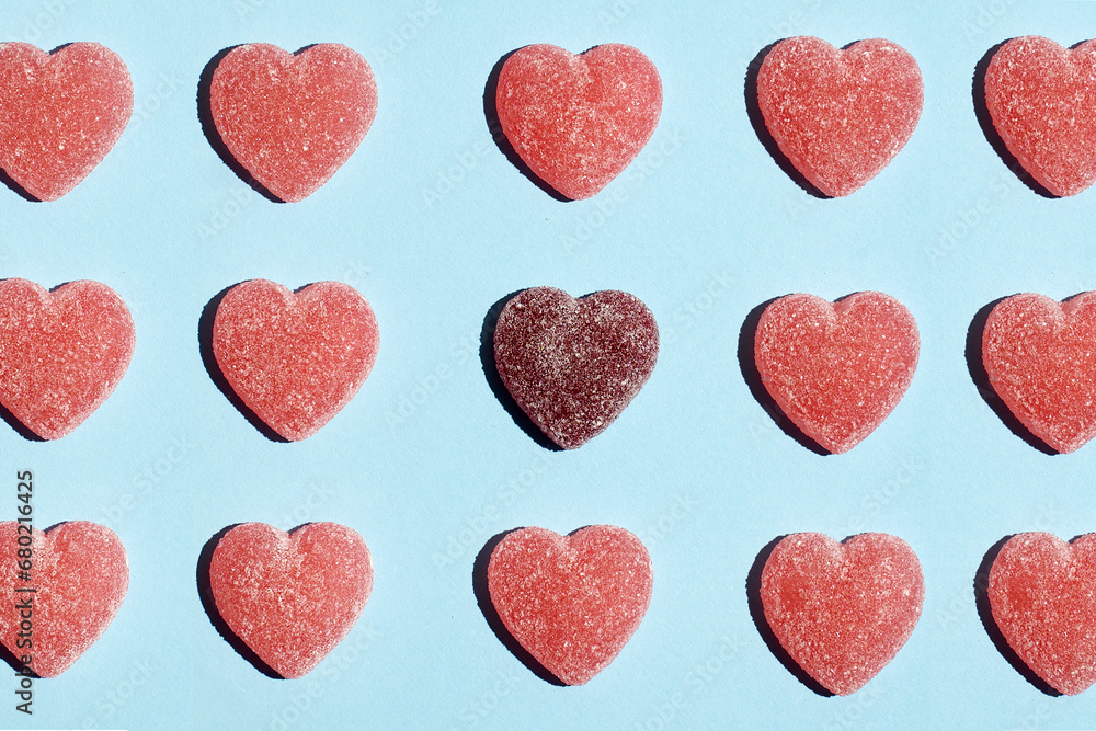Pattern of gummy vitamin candy in shape of heart on blue background .Concept photography. High quality photo