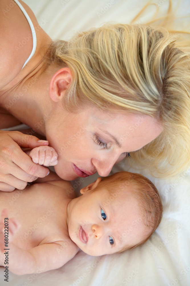 Relax, love and bed, mother and baby bonding, woman and kid lying in home together. Calm morning, mom and newborn in bedroom for rest, kiss and family wellness, comfort and child care from above. Relax, love and bed, mother and baby bonding, woman and kid lying in home together. Calm morning, mom and newborn in bedroom for rest, kiss and family wellness, comfort and child care from above.