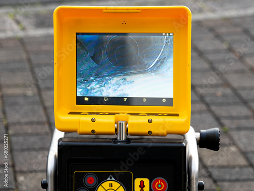 A drain cleaning company checks a blocked drain with a camera before flushing it out. Screen shows the cleaning process of the blocked pipe. photo