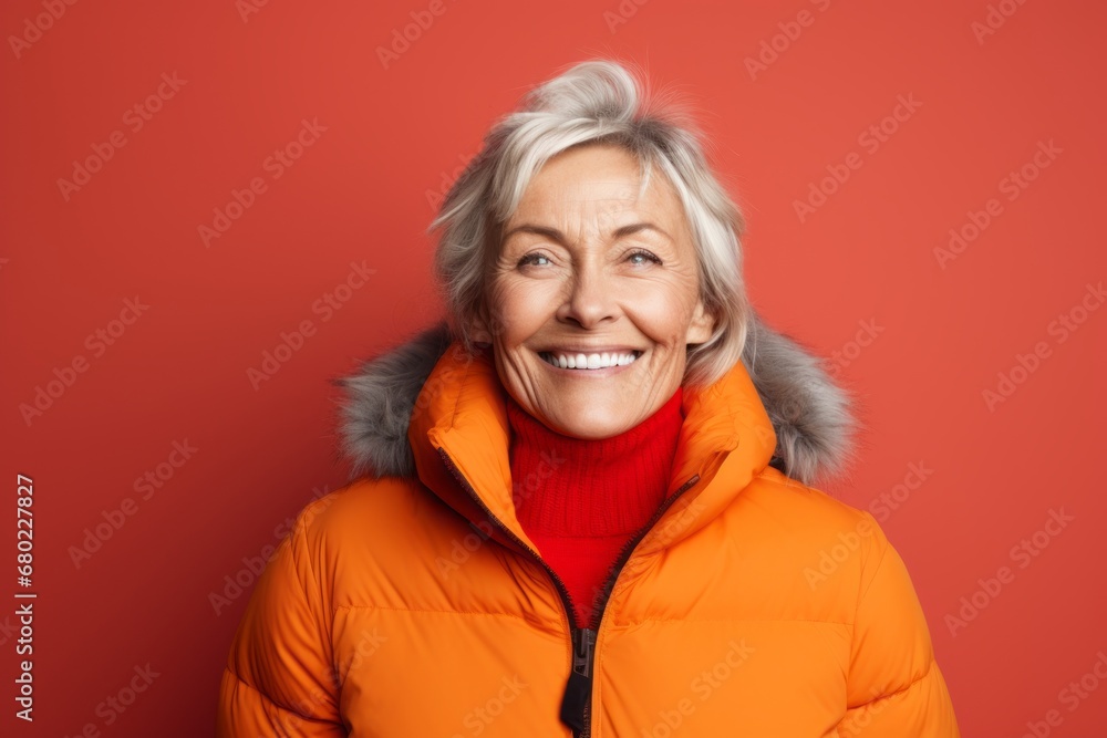Portrait of a happy woman in her 60s wearing a warm parka against a solid color backdrop. AI Generation Portrait of a happy woman in her 60s wearing a warm parka against a solid color backdrop. AI Generation