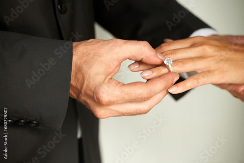 Man, hands and wedding ring on bride with diamond for marriage, commitment or love at ceremony. Closeup of groom putting jewelry on woman finger for couple engagement, proposal or romance together