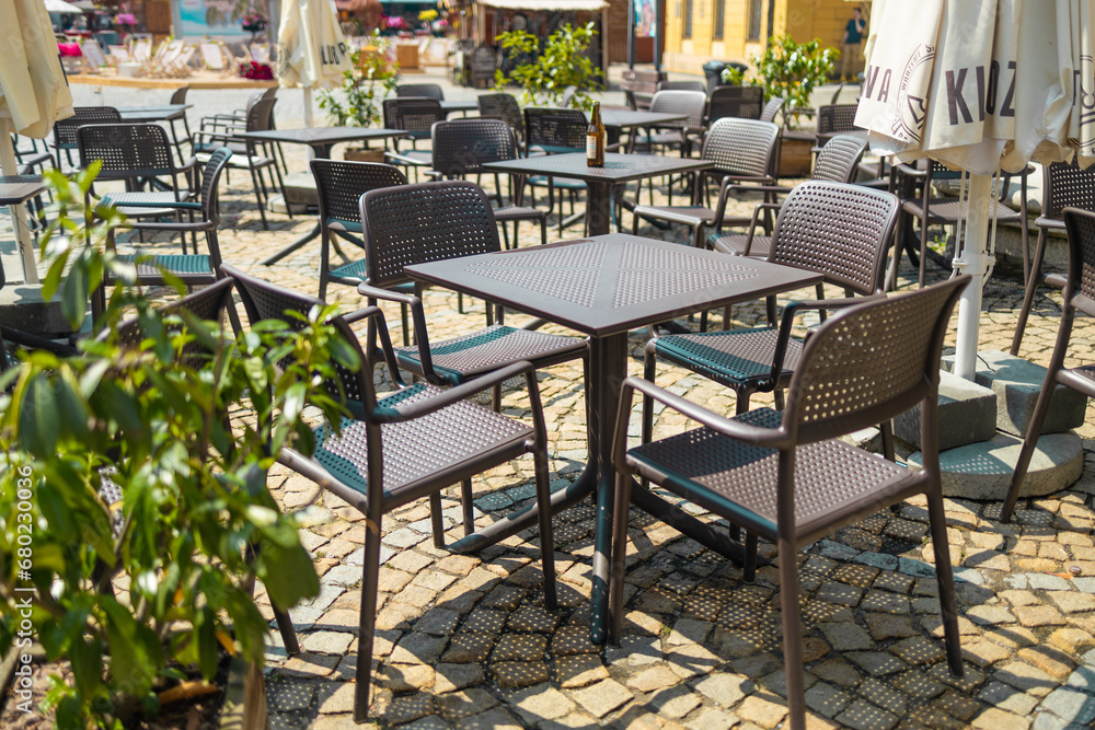 Cozy empty tables and chairs of outdoor cafe in european city.