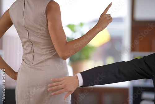 Hand, butt and sexual harassment with a business person slapping the behind of a woman coworker in the office. Ethics, behaviour or no with an employee reaching to smack the bottom of a colleague photo