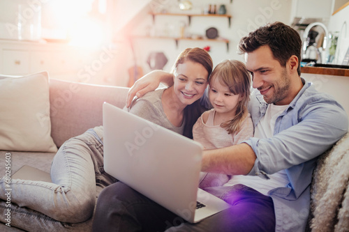 Family spending time together with laptop in living room