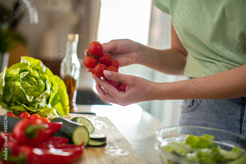Young woman preparing healthy vegetarian meal in kitchen