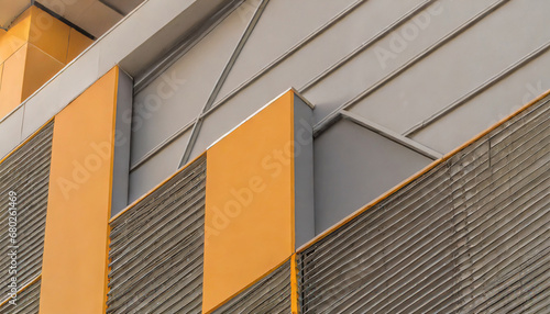 geometric color elements of the building facade with planes lines corners with highlights and reflections for an abstract background and texture of gray orange colors place for text
