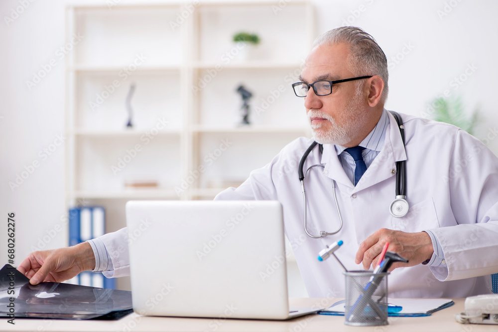 Old male doctor radiologist working in the clinic Old male doctor radiologist working in the clinic