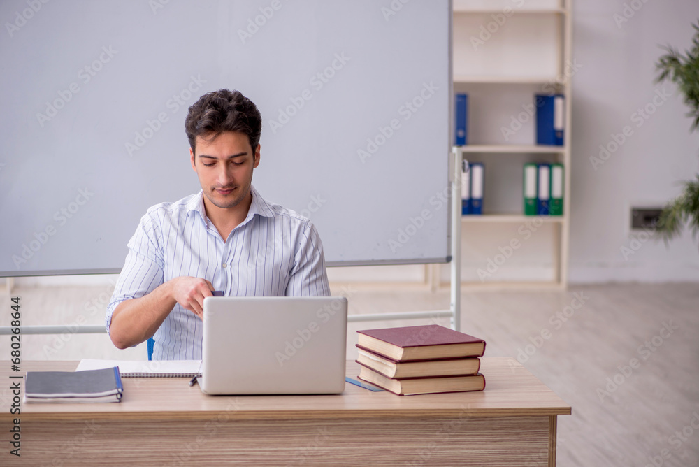 Young male teacher in front of white board Young male teacher in front of white board