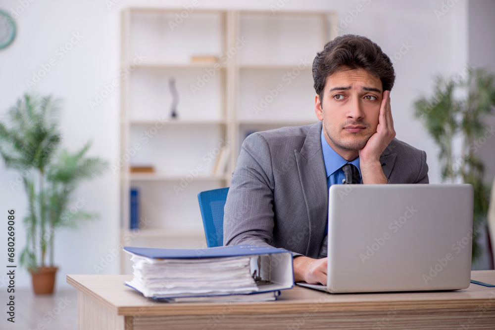 Young male employee working in the office Young male employee working in the office