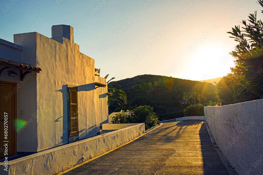 Obraz premium impressive sunset over hills with typical white greek houses in the foreground