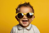baby with yellow sunglasses and yellow background