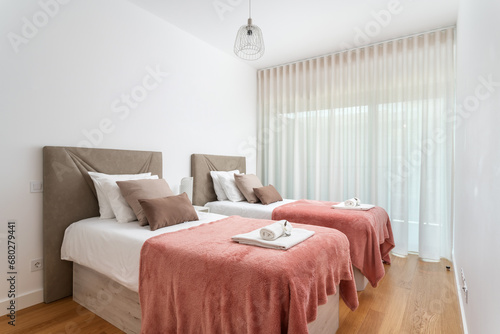 Double bed in the bright bedroom room interior furnishing furniture. With a red blanket and white towels on a roll. photo