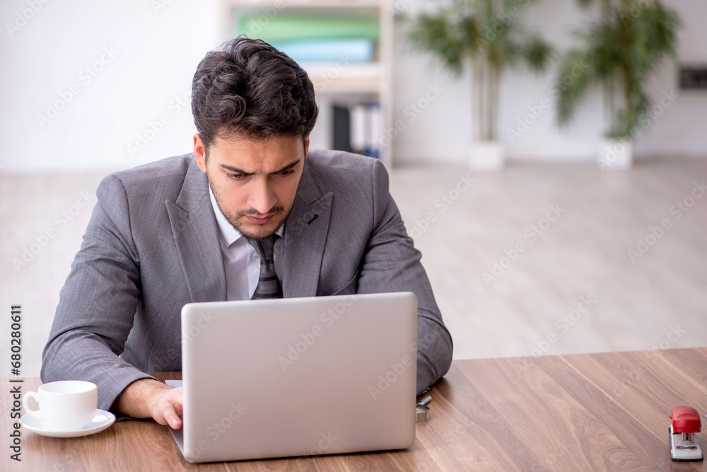 Young male employee working in the office Young male employee working in the office
