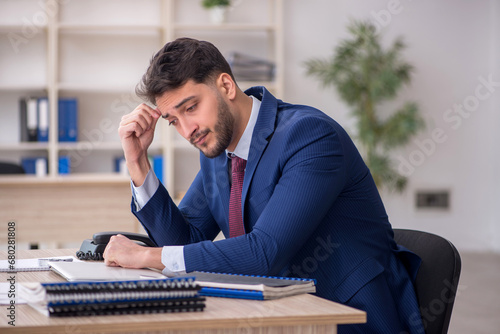 Young male employee working in the office photo