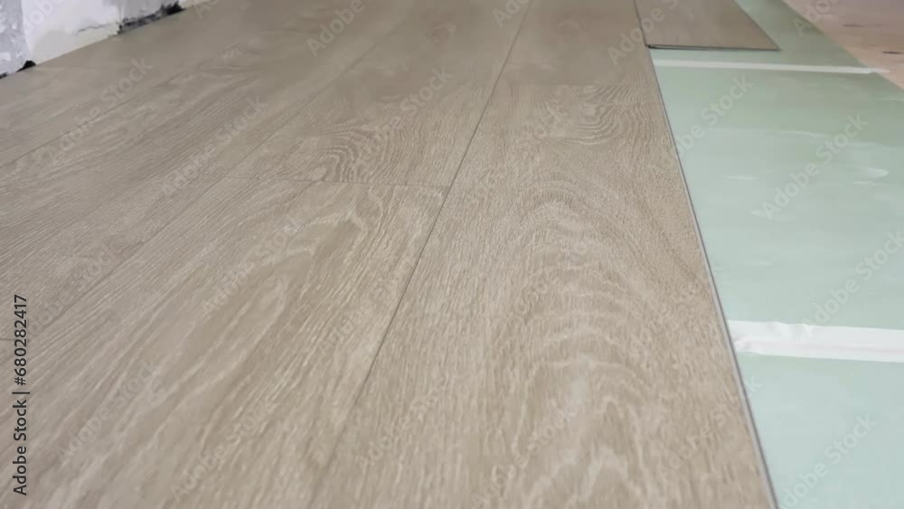 A man lays laminate flooring on the floor in a room, timing. A man lays laminate flooring on the floor in a room, timing.
