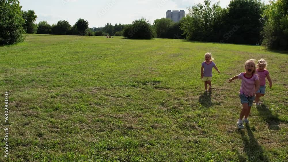 Triplet sister kids running on the grass Triplet sister kids running on the grass