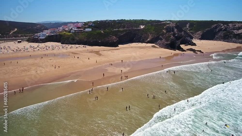 Aerial video filming by drone of sea bay and beach near the village of Odeceixe Alentejo Portugal. Beach with vacationing tourists and in the water.